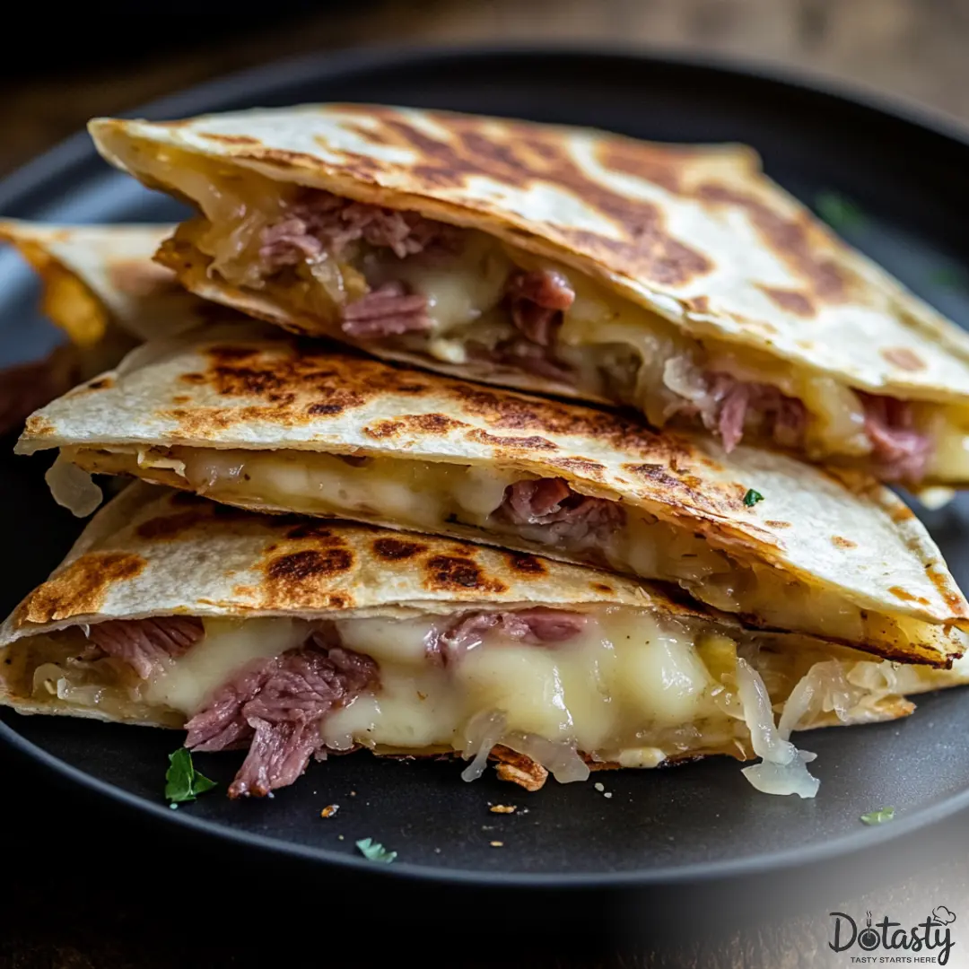 Crispy Reuben Quesadilla wedges showing layers of corned beef, sauerkraut, and melty Swiss cheese.