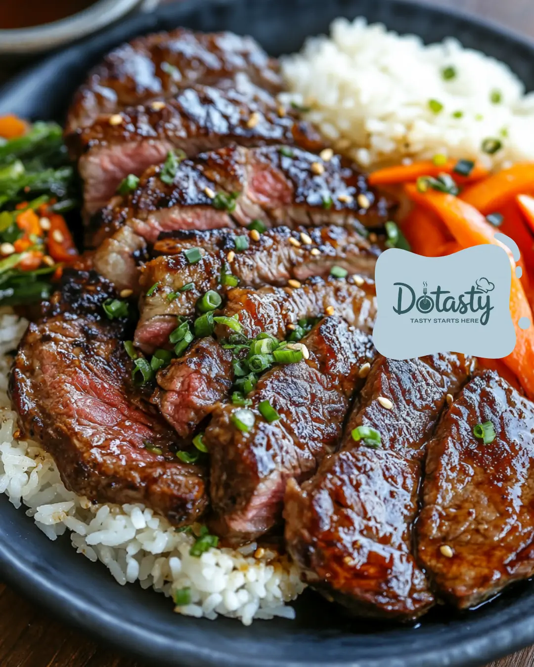 Grilled hibachi steak on a hot plate with rice and vegetables.