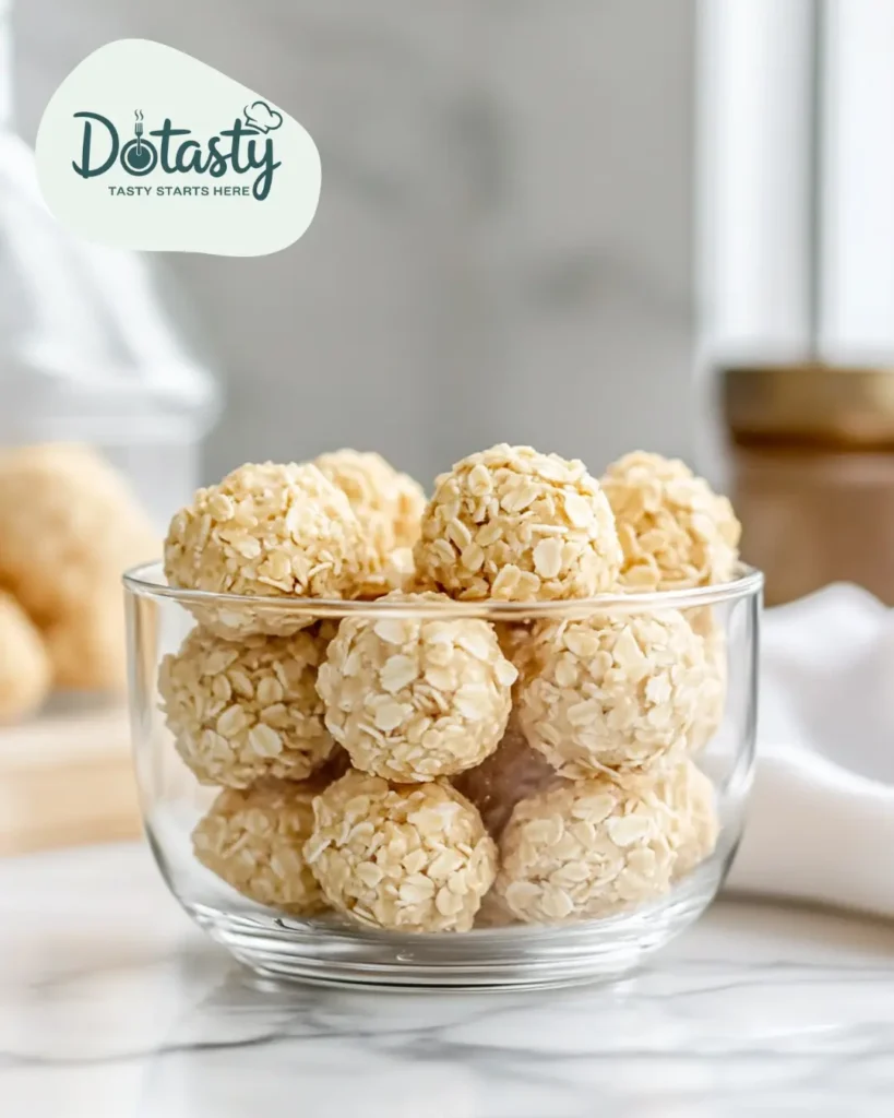 Lemon no bake cookies stored in a glass container with parchment