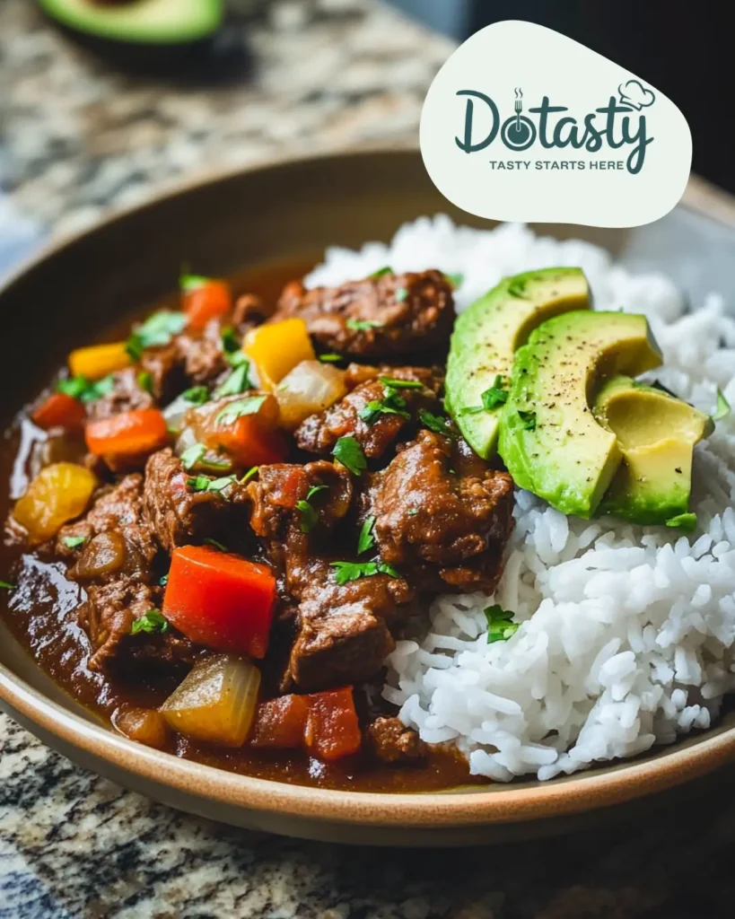 Puerto Rican beef stew served with rice and avocado slices